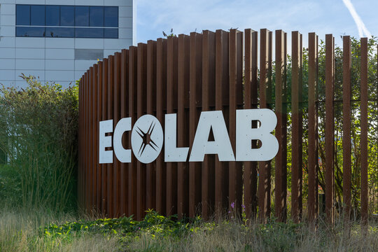 The Ecolab logo is prominently displayed on a unique curved wooden slatted sign, situated in front of a modern building with lush greenery. Leiden, Netherlands, 3 May 2025