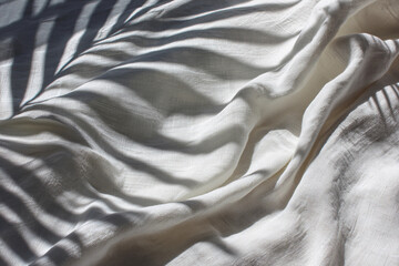 Sunlit white linen fabric with soft wrinkles and shadow lines, AI-generated