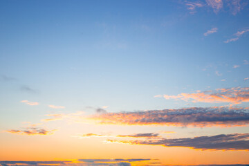 Blue evening sky with illuminated clouds at sunset. Celestial landscape