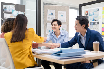 Asian businesswoman collaborates with coworkers in a modern office, discussing renewable energy strategies and ESG-focused solutions to promote sustainable business practices