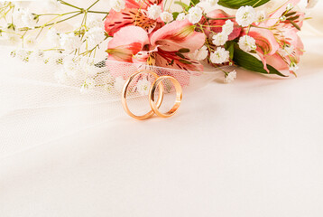 Wedding rings with flowers on elegant background