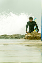 Surfer coming out of water after surfing session on cloudy morning