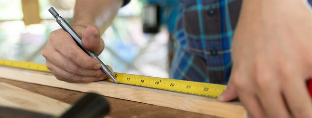 Hands of person doing diy project at home. Man measuring wood to doing cabinet craftworks as a...