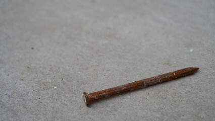 Close-up of rusty nail on concrete floor