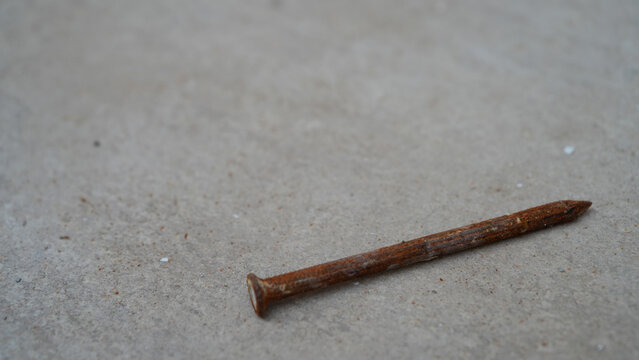 Close-up of rusty nail on concrete floor