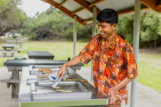 Indonesian enjoying outdoor barbecue in batik shirt