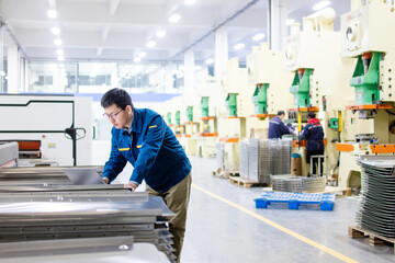 Asian engineers using laptop in factory