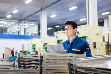 Asian engineers using laptop in factory