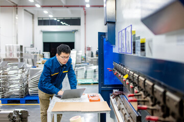 asian engineer working with laptop in factory