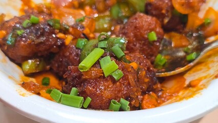 Close up shot of Chinese Manchurian with vegetables.