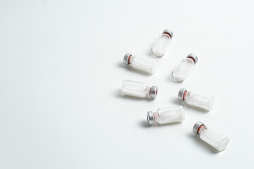 Flatlay of vaccine vial bottles with copy text space on white background. Flatlay of vaccine vials with white background, health medical concept.