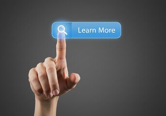 Hand touching 'Learn More' button. Technology, search, education. Gray background