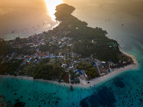 Aerial view of sunset on Koh Lipe Island with tranquil blue water and sandy beach, Mueang Satun, Thailand.