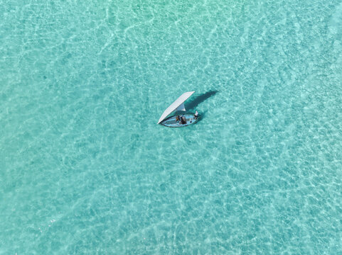 Aerial view of a traditional dhoni sailing in crystal clear turquoise water, Bileyfahi, Shaviyani Atoll, Maldives.