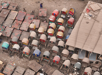 Dhaka, Bangladesch - 17 February 2025: Aerial view of a bustling urban market with colorful rickshaws and busy street life, Dhaka, Dhaka, Bangladesh.