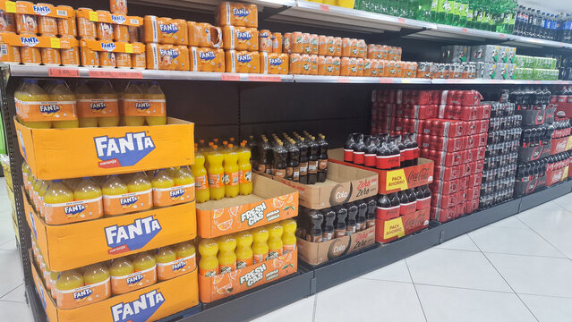 Roquetas de Mar, Almeria, Andalusia, Spain, May 21, 2025: fanta bottles with lemon, cola and soda are in almost perfect order on supermarket shelves