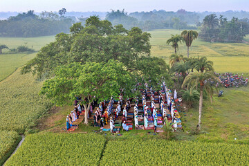 Satkhira, Bangladesh - 11 April 2024: Aerial view of people gathered for Eid prayer amidst lush greenery and fields, Satkhira, Khulna, Bangladesh.