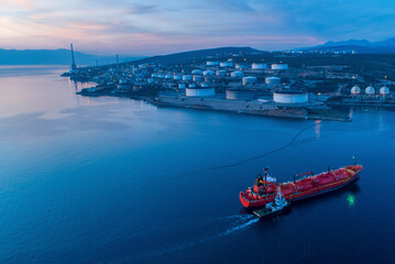 Aerial view of INA Oil Refinery with calm sea and storage tanks at sunset, Rijeka, Croatia.
