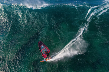 Aerial view of surfers riding waves on funboards in a beautiful ocean, Maui, Hawaii, United States.