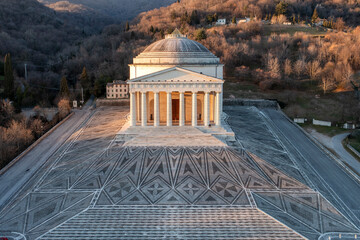 Aerial view of canova temple with neoclassical columns surrounded by scenic mountains and trees, Possagno, Treviso, Italy.