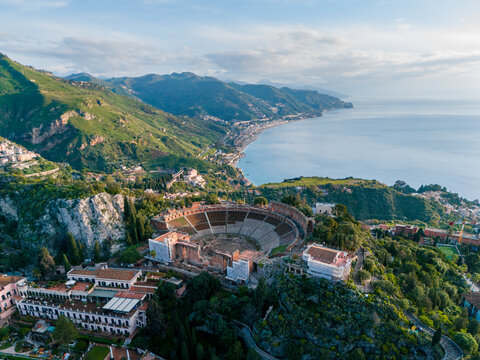 Aerial drone view of Teatro Antico di Taormina during sunrise, Island of Sicily, italy