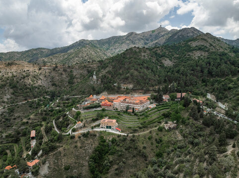Aerial view of the serene Holy Monastery of Panagia Machaira surrounded by picturesque mountains and greenery, Troodos Mountains, Nicosia, Cyprus.