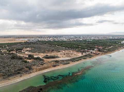 Aerial view of ancient ruins along a picturesque coastline with green water and sandy beach, Agios Sergios, Famagusta, Turkish Republic of Northern Cyprus.