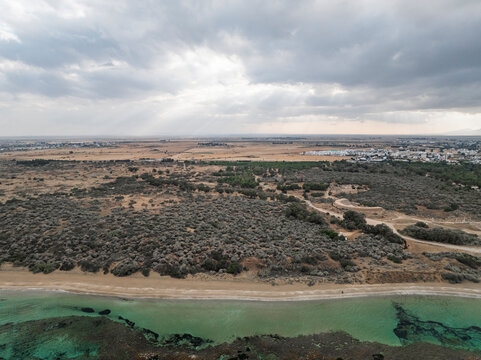 Aerial view of ancient salamis with serene beach and rugged coastline, Agios Sergios, Famagusta, Turkish Republic of Northern Cyprus.