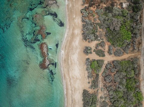 Aerial view of beautiful turquoise beach with serene coastline and rocks, Agios Sergios, Famagusta, Turkish Republic of Northern Cyprus.