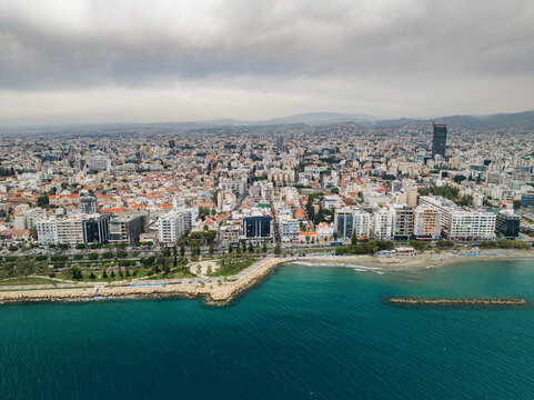 Aerial view of beautiful modern cityscape with residential buildings by the coast and skyline overlooking the sea, Limassol, Cyprus.