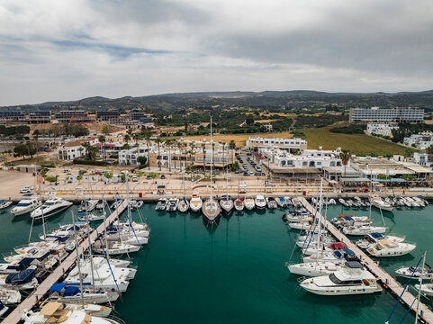 Aerial view of marina filled with yachts and boats under a sunny sky, Lachi, Paphos, Cyprus.