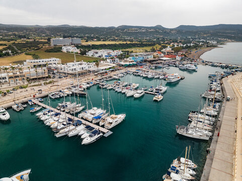 Aerial view of a picturesque marina with moored yachts and coastal buildings, Lachi, Paphos, Cyprus.
