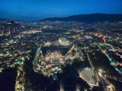 Aerial view of the illuminated Acropolis and Parthenon at twilight over the cityscape of Athens, Attica, Greece.