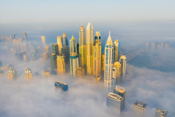 Aerial view of dubai marina with iconic skyscrapers and clouds, dubai, united arab emirates.