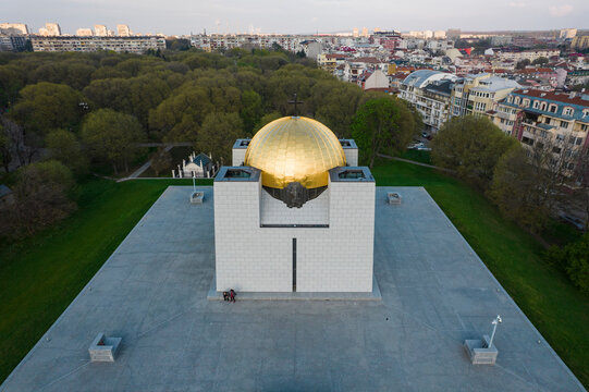 Aerial view of pantheon of national revival heroes with golden dome surrounded by urban landscape and greenery, Ruse, Ruse, Bulgaria.
