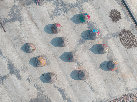 Aerial view of a rice mill with workers in hats and shadows on concrete, Dhaka, Dhaka, Bangladesh.