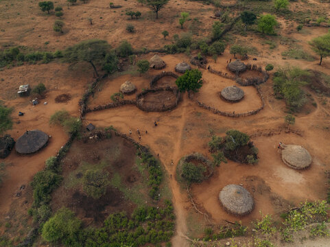 Aerial view of traditional hamar tribe village with huts and trees along a dirt road, Southern Nations Nationalities and Peoples' Region, Ethiopia.