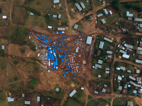 Aerial view of a vibrant tribal market with blue tents and people gathering, Kako, Southern Nations Nationalities and Peoples' Region, Ethiopia.