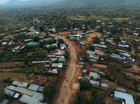 Aerial view of a tranquil rural village with traditional homes and a dirt road surrounded by lush greenery and hills, Kako, Southern Nations Nationalities and Peoples' Region, Ethiopia.