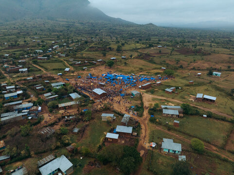 Aerial view of a vibrant tribal market in a rural village surrounded by mountains and hills, Kako, Southern Nations Nationalities and Peoples' Region, Ethiopia.
