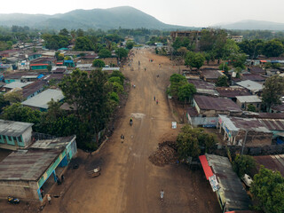 Aerial view of a rural town with buildings, dirt roads, and greenery surrounded by hills, Baka, Southern Nations Nationalities and Peoples' Region, Ethiopia.