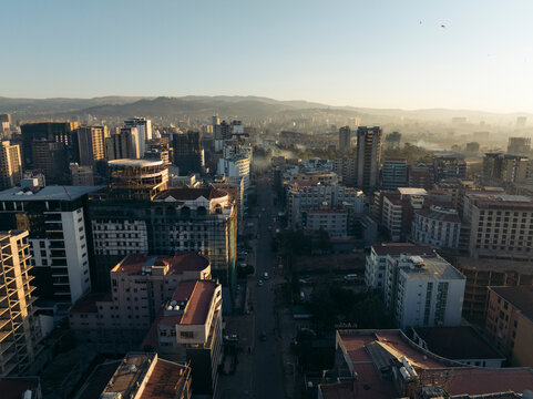 Aerial view of busy urban landscape with modern skyscrapers and vibrant city life at sunset, Cameroon Street, Addis Ababa, Ethiopia.