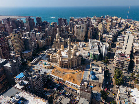 Aerial view of sidi morsi abu al-abbas mosque surrounded by bustling cityscape and coastal sea, El Mazar, Alexandria, Egypt.