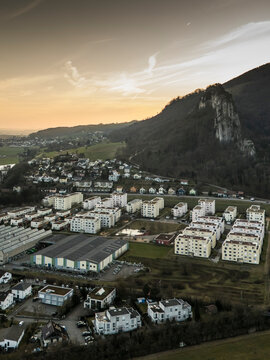 Aerial view of a beautiful cityscape with residential buildings and mountains under a scenic sunset, Oensingen, Solothurn, Switzerland.