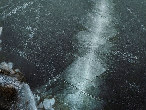 Aerial view of frozen lake with intricate ice patterns and white snow, Trakai, Trakai, Lithuania.