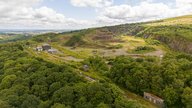 Aerial view of an abandoned quarry surrounded by lush greenery and hills, Meldon, Okehampton, United Kingdom.