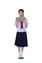 Happy Asian schoolgirl in school uniform using tablet computer while standing isolated on white background. Full body photo