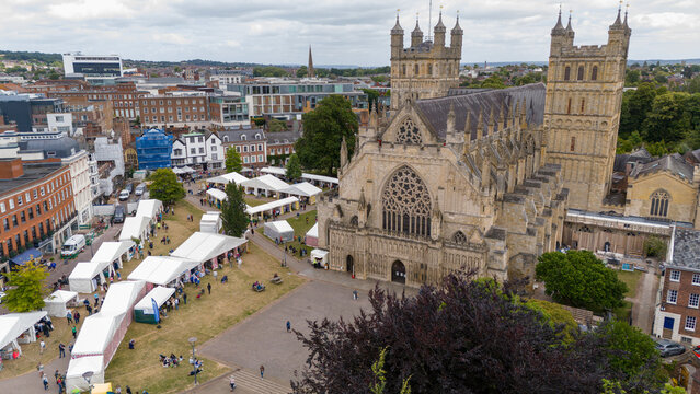 Aerial view of bustling exeter cathedral surrounded by tents and people in a vibrant market, exeter, united kingdom.