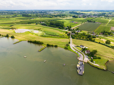 Aerial view of river Nederrijn with floodplains, fruit orchards and crossing ferry between Eck en Wiel and Amerongen, Gelderland, Netherlands.