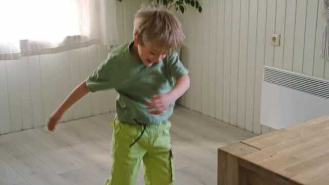 6 years kid dance. Child jumping and dancing have fun at home listens song, moves to music, feels overjoyed, celebrate good news, relish carefree life looks happy. Boy cheering and celebrating success